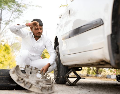 tyre puntured of man sitting on road