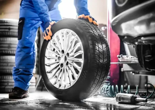 mobile tyre fitting technician rolling tyre